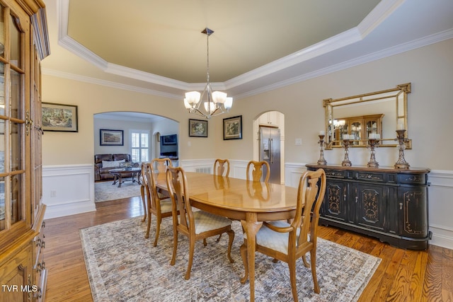 dining room featuring a chandelier, ornamental molding, hardwood / wood-style flooring, and a tray ceiling