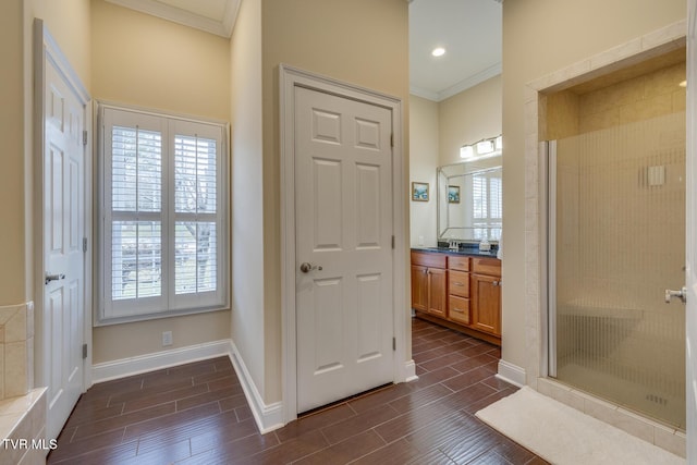 bathroom featuring vanity, a shower with shower door, and ornamental molding