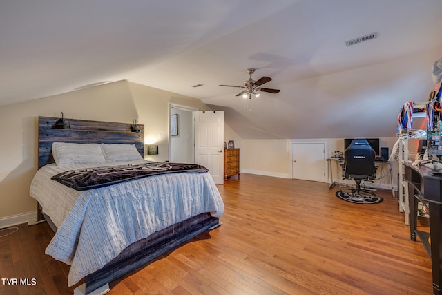 bedroom featuring ceiling fan, hardwood / wood-style floors, and vaulted ceiling