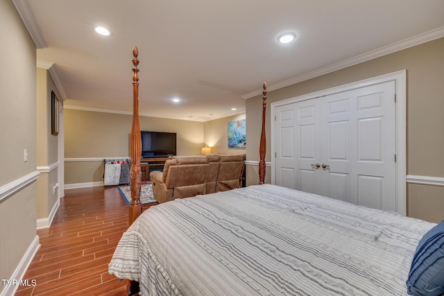 bedroom with hardwood / wood-style flooring, ornamental molding, and a closet