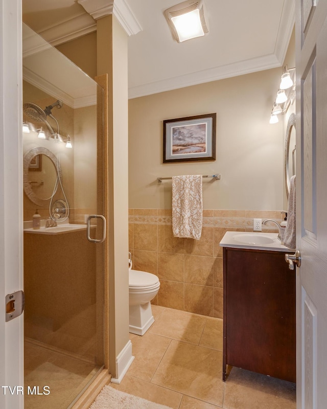 bathroom with tile patterned floors, a shower with door, vanity, tile walls, and ornamental molding