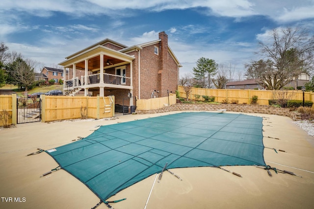 view of pool featuring a diving board, ceiling fan, and a patio area