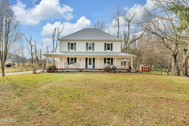 country-style home featuring a front lawn, a porch, and a storage shed