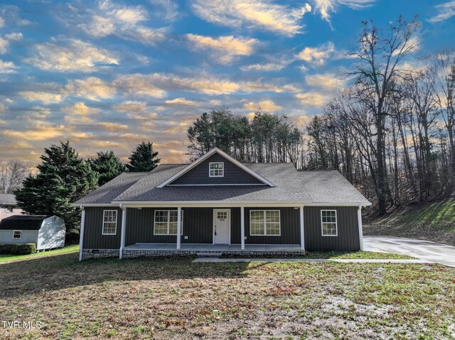 view of front of house with a porch and a yard