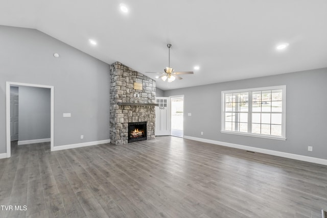 unfurnished living room with a fireplace, wood-type flooring, vaulted ceiling, and plenty of natural light