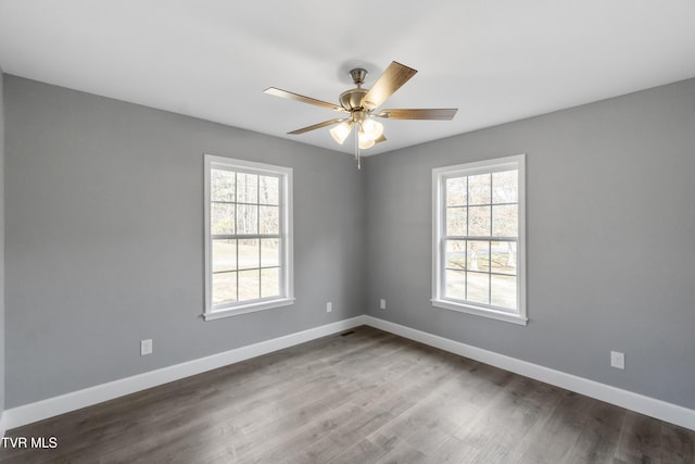 empty room featuring ceiling fan, hardwood / wood-style floors, and a healthy amount of sunlight