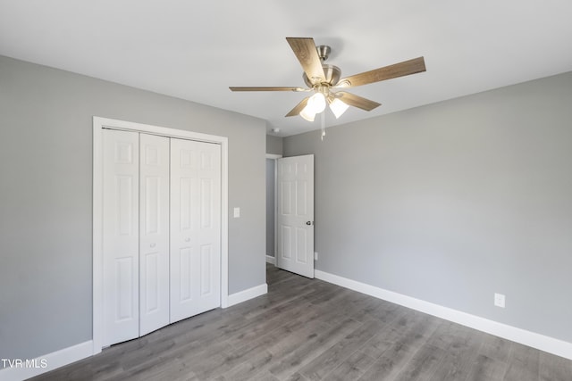 unfurnished bedroom featuring ceiling fan, a closet, and hardwood / wood-style floors