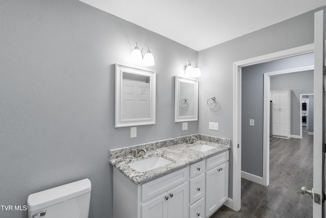 bathroom with hardwood / wood-style flooring, vanity, and toilet