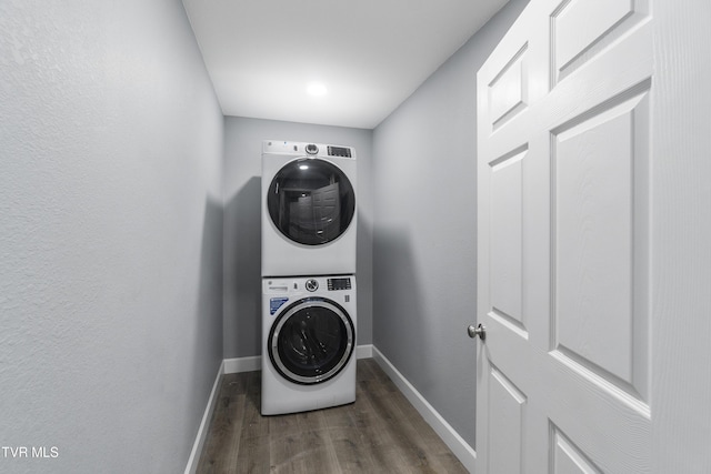 washroom with dark hardwood / wood-style floors and stacked washer / dryer