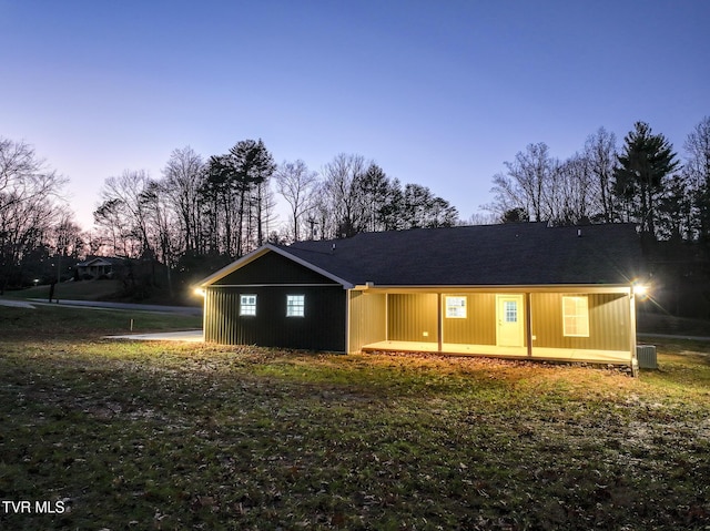 view of front of house with a yard and central air condition unit