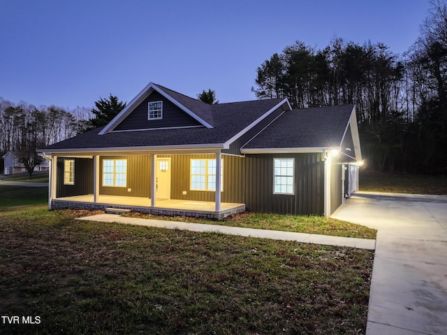 ranch-style home featuring covered porch, a garage, and a lawn