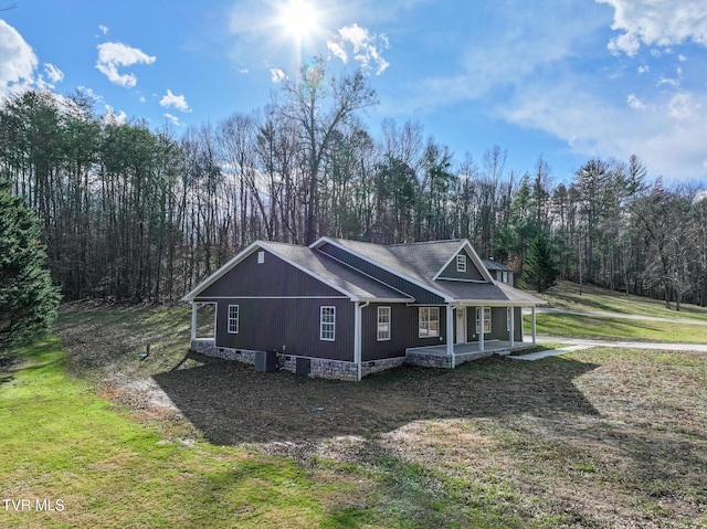 exterior space featuring covered porch, central AC unit, and a lawn