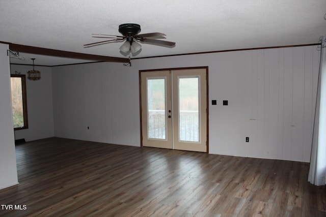 spare room featuring ceiling fan, french doors, wood-type flooring, a textured ceiling, and wooden walls