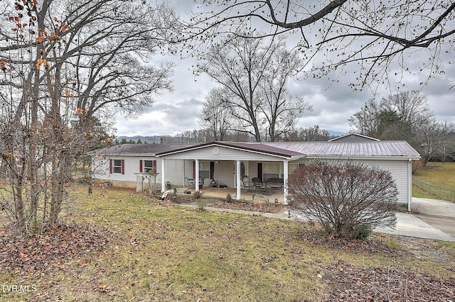 manufactured / mobile home with a front yard and a porch