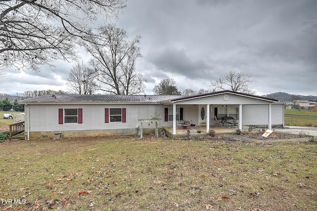 manufactured / mobile home featuring a patio and a front yard