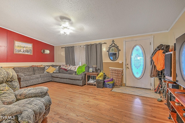 living room featuring a textured ceiling, wood-type flooring, and ornamental molding