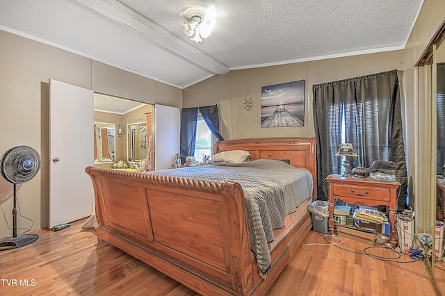 bedroom with hardwood / wood-style floors, vaulted ceiling with beams, a textured ceiling, and crown molding