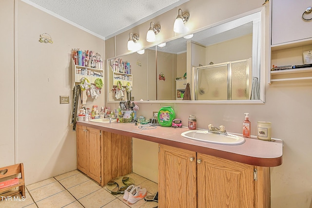 bathroom featuring tile patterned flooring, vanity, an enclosed shower, and a textured ceiling