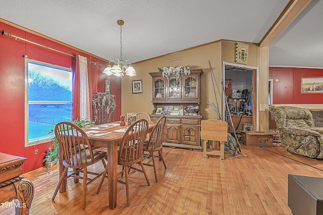 dining area with wood-type flooring, a textured ceiling, an inviting chandelier, and ornamental molding