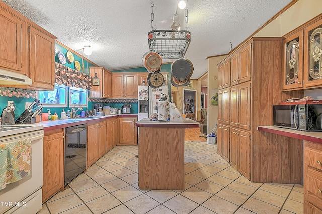 kitchen featuring light tile patterned flooring, a textured ceiling, a center island, and black appliances