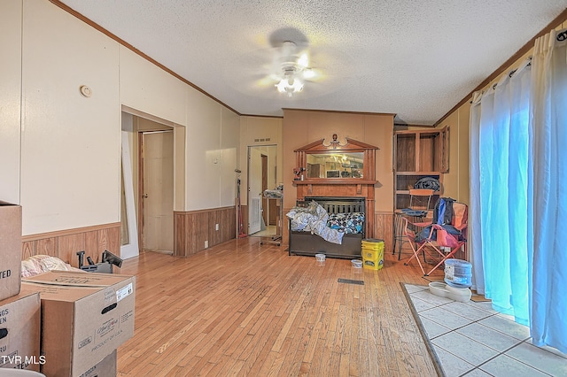 interior space with ceiling fan, crown molding, light hardwood / wood-style floors, and a textured ceiling