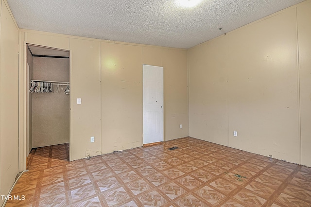 unfurnished bedroom featuring a textured ceiling and a closet