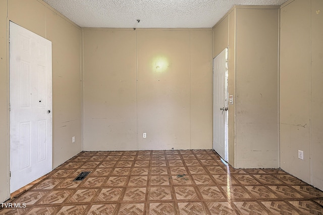 unfurnished room with a textured ceiling