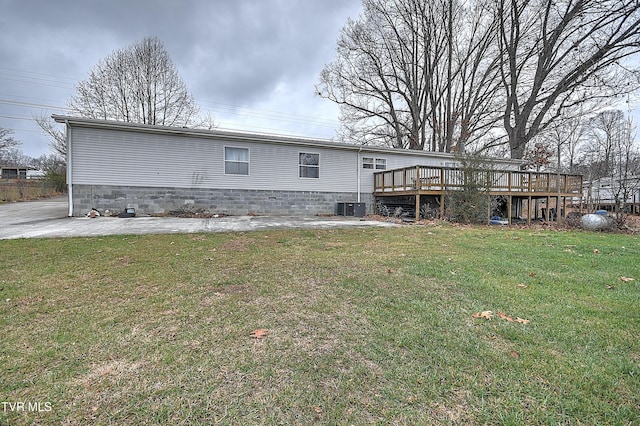 back of property featuring a lawn, a deck, and central AC