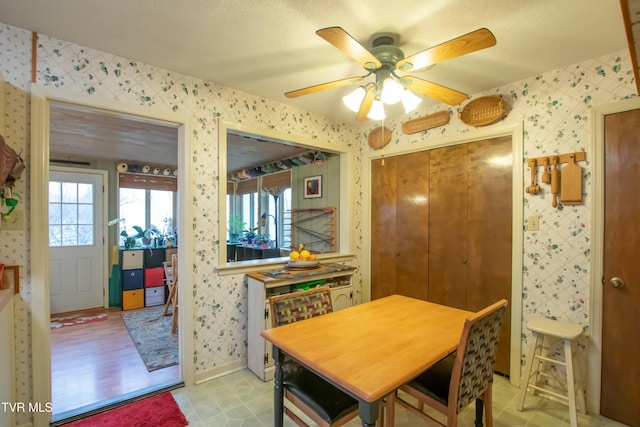 dining area featuring ceiling fan, a textured ceiling, and light wood-type flooring