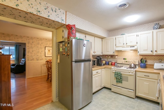 kitchen featuring white cabinets, appliances with stainless steel finishes, and light hardwood / wood-style floors