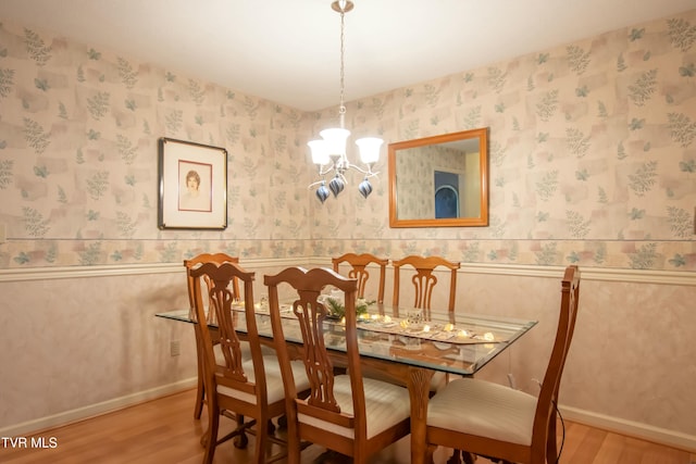 dining room with hardwood / wood-style floors and an inviting chandelier