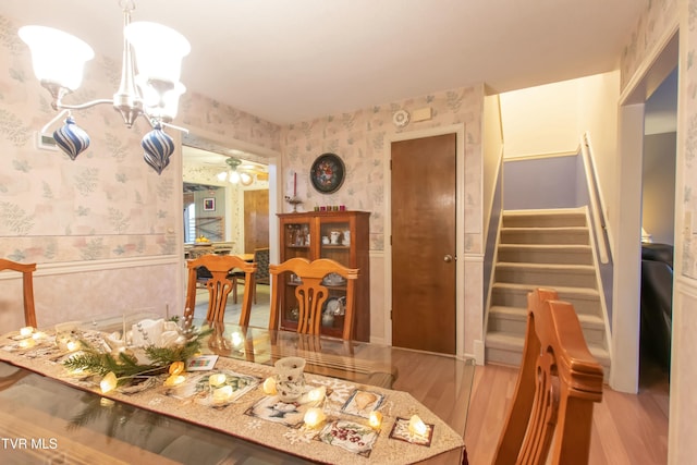 dining room featuring ceiling fan with notable chandelier and light wood-type flooring