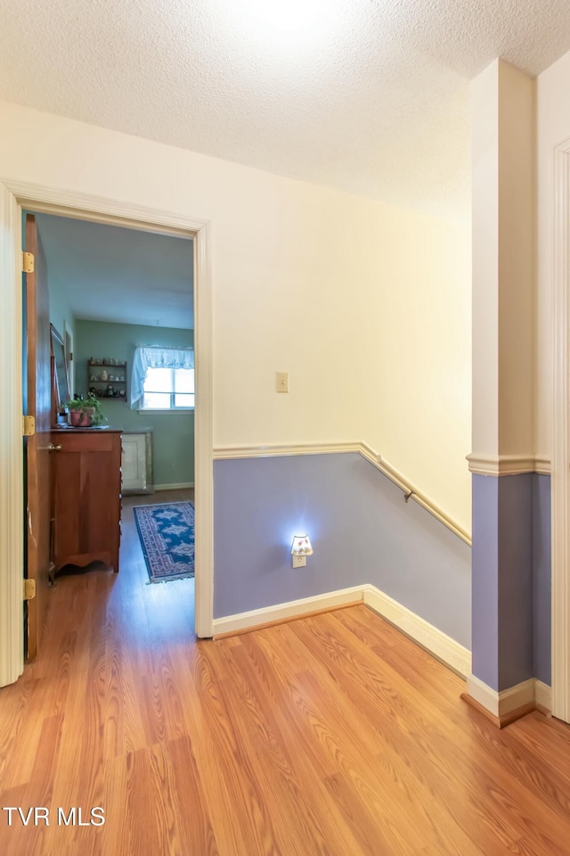 unfurnished room featuring hardwood / wood-style flooring and a textured ceiling