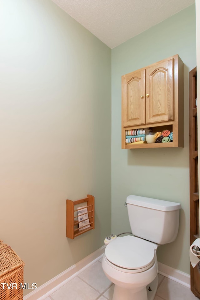 bathroom featuring tile patterned flooring, toilet, and a textured ceiling