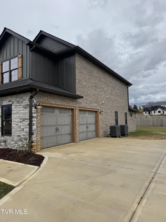 view of home's exterior with a garage and central AC