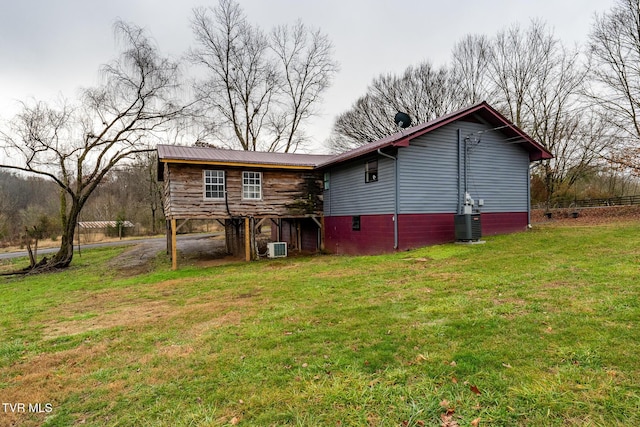 back of property featuring a lawn and central AC unit