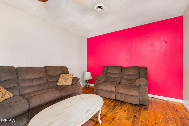 living room featuring wood-type flooring and a textured ceiling