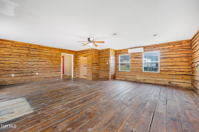 empty room with ceiling fan, dark hardwood / wood-style flooring, log walls, and a wall mounted AC