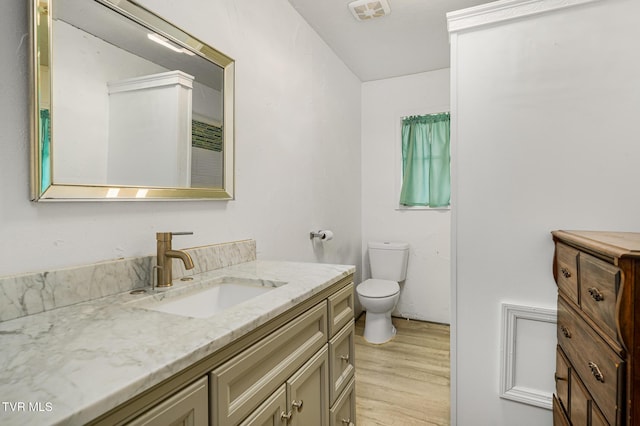 bathroom with vanity, wood-type flooring, and toilet