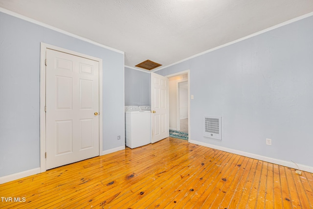 unfurnished bedroom with light wood-type flooring, ornamental molding, and washing machine and clothes dryer