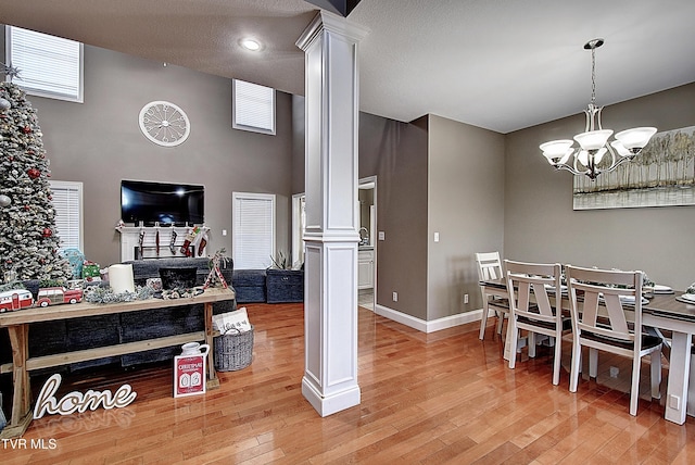 dining space with an inviting chandelier, hardwood / wood-style flooring, and ornate columns