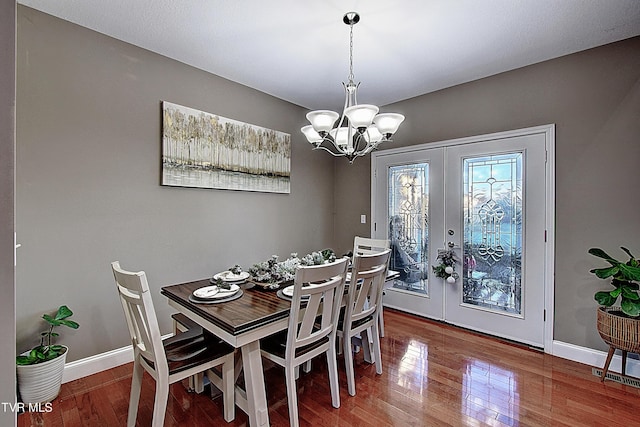 dining room featuring a notable chandelier, wood-type flooring, and french doors