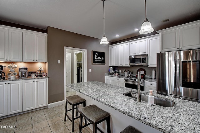 kitchen featuring white cabinets, stainless steel appliances, and light stone countertops