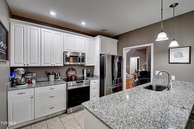 kitchen with a kitchen island with sink, white cabinets, hanging light fixtures, sink, and appliances with stainless steel finishes