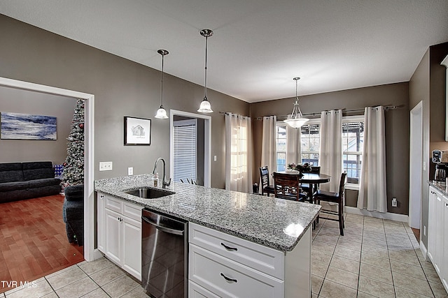 kitchen featuring light stone counters, sink, light tile patterned floors, decorative light fixtures, and white cabinets