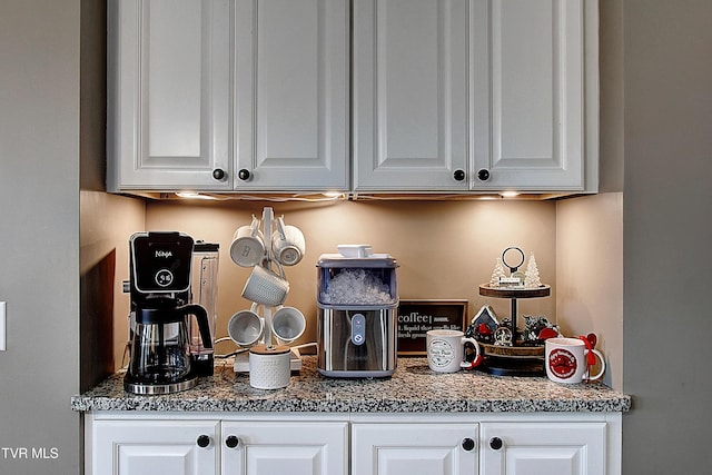 interior space featuring white cabinets and dark stone counters