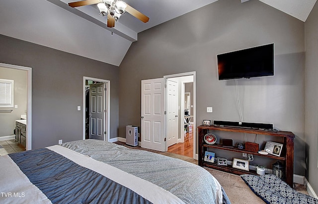 bedroom with ensuite bath, ceiling fan, light carpet, and vaulted ceiling