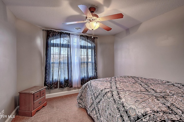 carpeted bedroom with ceiling fan and a textured ceiling