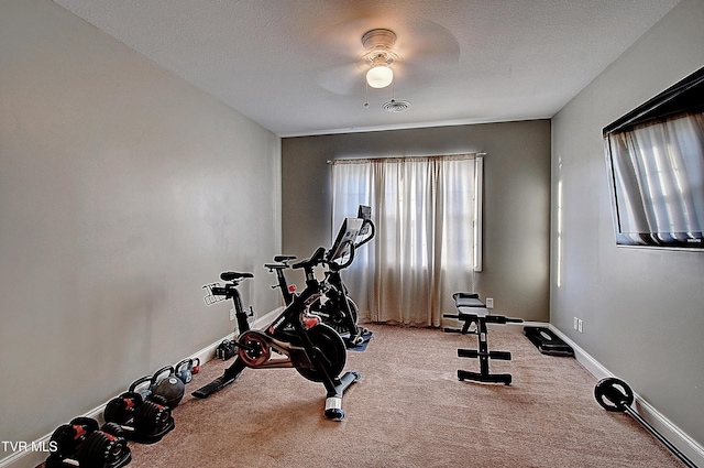 workout area with carpet, ceiling fan, and a textured ceiling