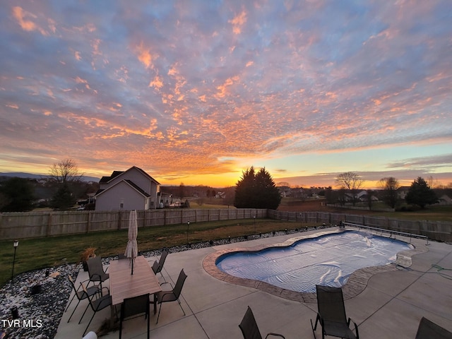 pool at dusk featuring a lawn and a patio area